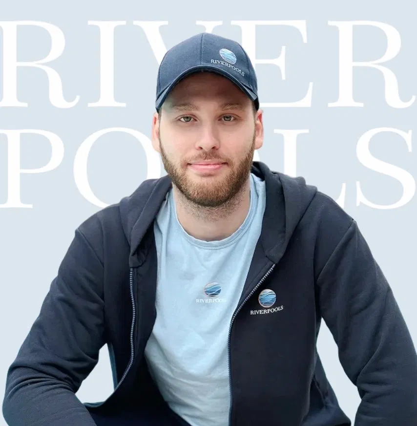 team_specialist — специалист RiverPools на фоне брендовой стены